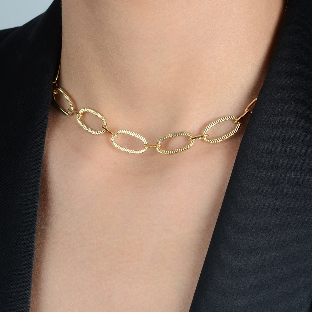 Detalhe da choker dourada Ayren com corrente e extensor
